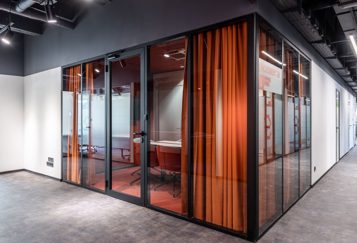 Un espace professionnel contemporain avec des salles vitrées et des rideaux orangés